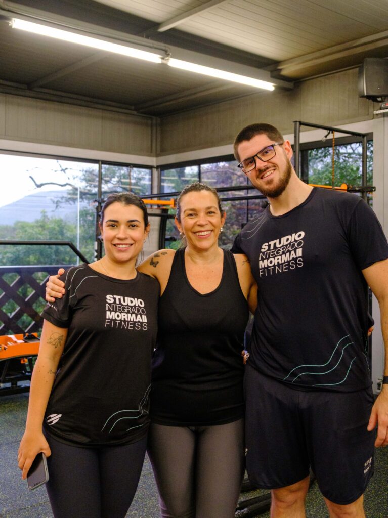 Professores abraçando aluna do Studio Mormaii