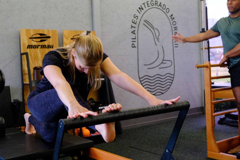 Aluna do Studio Mormaii em exercício de Pilates com orientação da professora